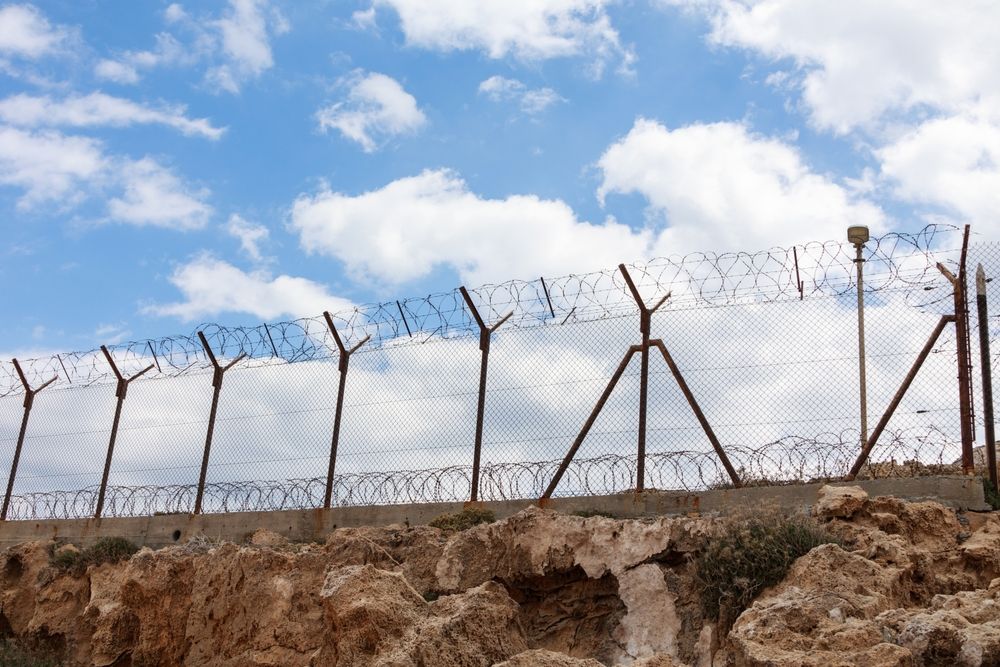 Barbed,Wire,Fence,On,A,Blue,Sky,Background.,A,Large, migráns, migráció