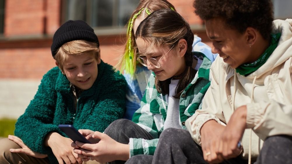 Teenage,Girl,In,Eyeglasses,Communicating,Online,On,Mobile,Phone,While