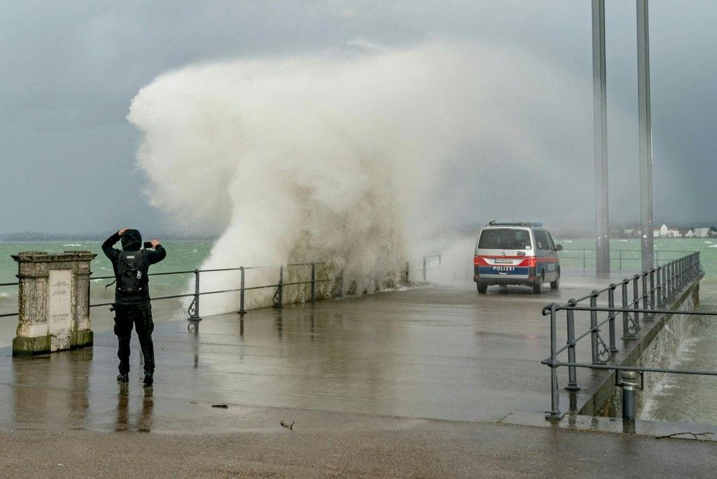 A man photographs while water spills over a quay in the Eastern end of Lake Constance (Bodensee), as the storm Ciara reaches Austria, in Bregenz, Austria, on February 10, 2020. (Photo by DIETMAR STIPLOVSEK / APA / AFP) / Austria OUT