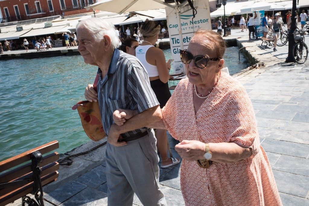 A couple is walking at the Old Venetian Port of Chania in Chania, Crete Island, Greece, on August 16, 2024. Hypertourism in Greece and especially in the islands is welcoming more tourists compared to 2023, resulting in a new tourism record. (Photo by Nikolas Kokovlis/NurPhoto) (Photo by Nikolas Kokovlis / NurPhoto / NurPhoto via AFP)