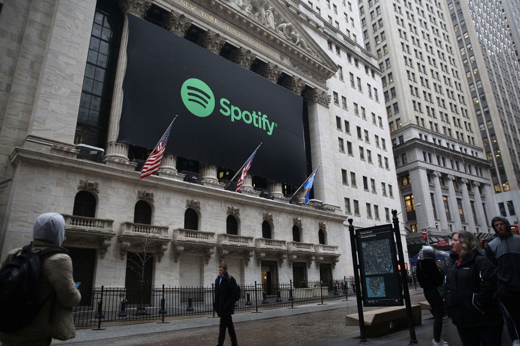 NEW YORK, USA - APRIL 3: People walk past a banner with the Spotify logo on as the company lists its stock on the New York Stock Exchange in New York, United States on April 3, 2018. Mohammed Elshamy / Anadolu Agency (Photo by Mohammed Elshamy / ANADOLU AGENCY / Anadolu via AFP)