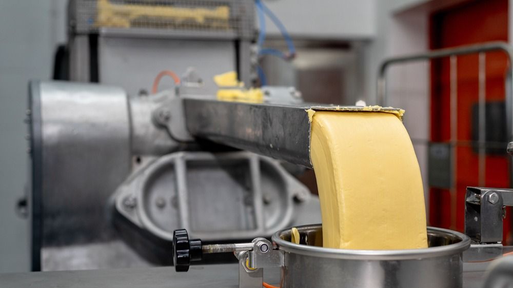 Butter,Jetting,In,Factory,With,Machinery,Background