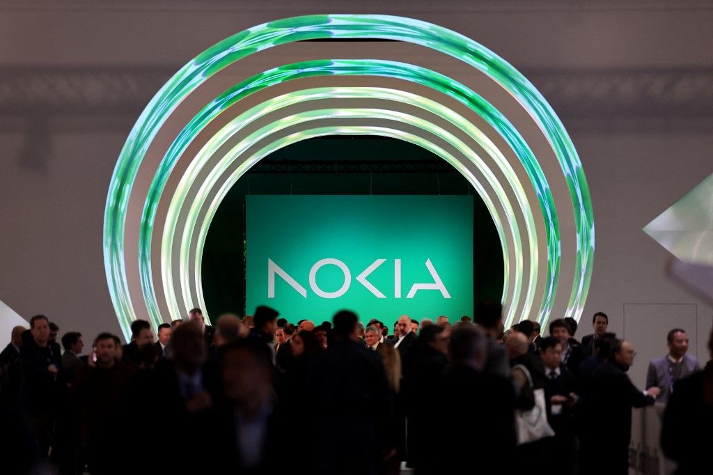 Visitors walk past near the Nokia stand at the Mobile World Congress (MWC), the telecom industry's biggest annual gathering, in Barcelona on February 27, 2023. (Photo by Thomas COEX / AFP)