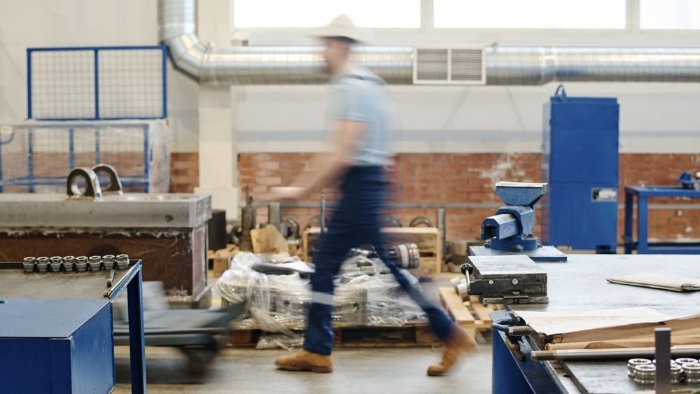 Long,Motion,Blur,Shot,Of,Unrecognizable,Walking,Along,Factory,Workshop fizikai munka