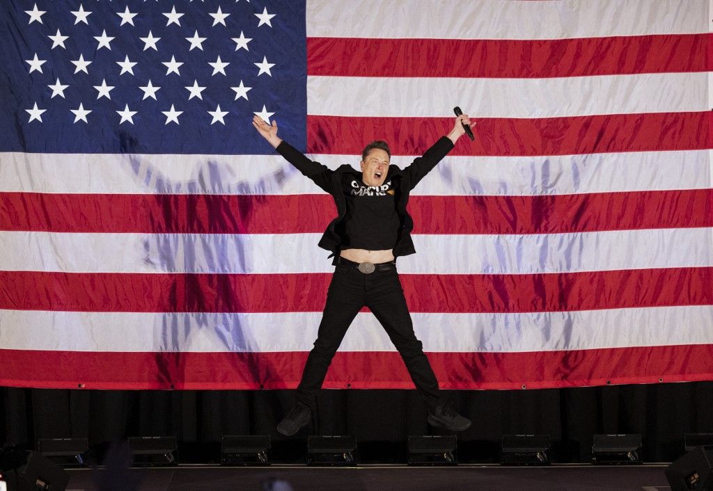 Tesla, Elon Musk and America PAC host town hall eventTesla and SpaceX CEO Elon Musk jumps on stage as he arrives to speak at a town hall event hosted by America PAC in support of former US President and Republican presidential candidate Donald Trump at the Greater Philadelphia Expo Center in Oaks, Pennsylvania, on October 18, 2024. Musk is holding several events in the key swing-state of Pennsylvania in support of former US President and Republican presidential candidate Donald Trump. (Photo by RYAN COLLERD / AFP)