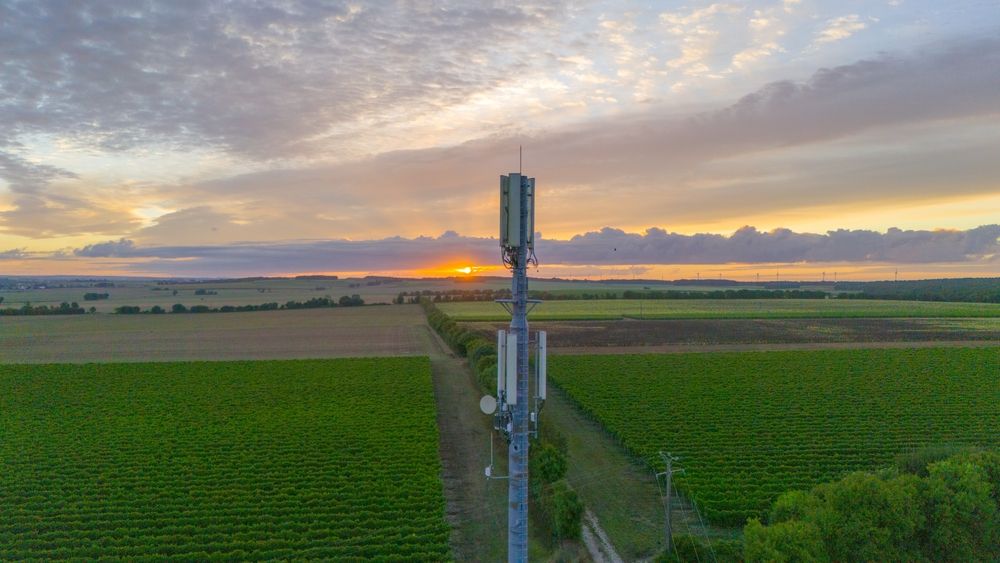 5g,Tower,Overlooking,Fields,During,Sunrise