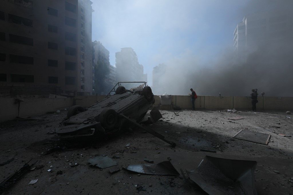 A picture taken during a tour organised by Hezbollah media office on October 2, 2024 shows a destroyed car as smoke billows from the site of an Israeli airstrike on a neighbourhood in Beirut's southern suburbs. (Photo by AFP)
közel-kelet