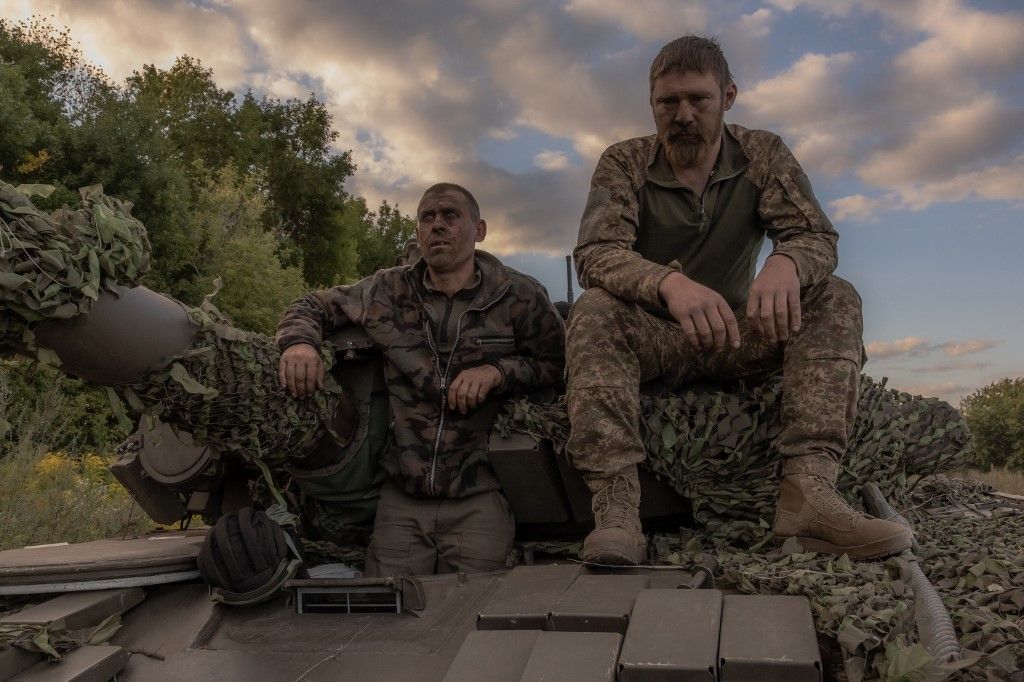 Ukrainian tank crew take a break while operating a Soviet-made T-72 tank in the Sumy region, near the border with Russia, on August 12, 2024, amid the Russian invasion of Ukraine. Ukraine launched a surprise offensive into the Russian border region of Kursk on August 6, 2024, capturing over two dozen towns and villages in the most significant cross-border attack on Russian soil since World War II. Ukraine's military chief Oleksandr Syrsky told President Volodymyr Zelensky in a video posted on August 12, 2024 that his troops now control about 1,000 square kilometres of Russian territory and are continuing "offensive operations". (Photo by Roman PILIPEY / AFP)