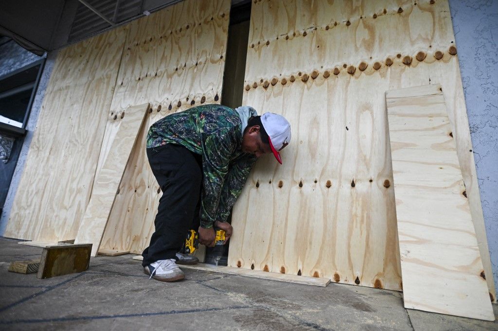 On heels of Helene, storm Milton expected to strengthen into major hurricane and slam Florida
A worker boards a window in Tampa, Florida, on October 8, 2024, ahead of Hurricane Milton's expected landfall. Milton regained power on October 8 to become a Category 5 storm with maximum sustained winds of 165 mph (270 kph) as it barrels towards west-central coast of Florida forecast to make landfall late October 9, according to the National Hurricane Center. (Photo by Miguel J. Rodriguez Carrillo / AFP) Milton hurrikán