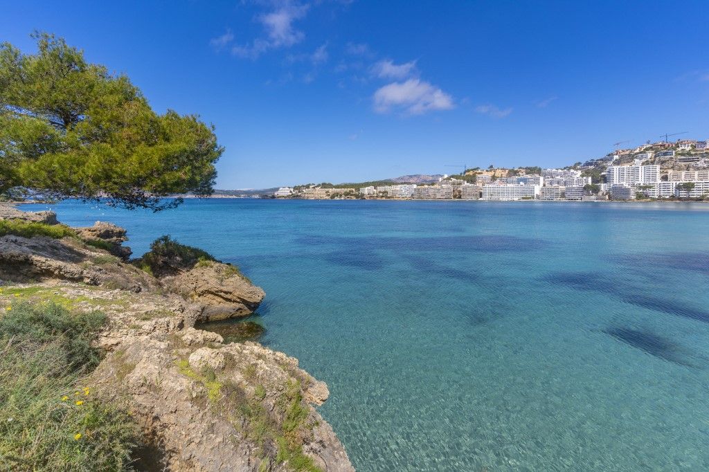 View of rocky shoreline by turquoise sea and Santa Ponsa, Majorca, Balearic Islands, Spain, Mediterranean, Europe, spanyol, tengerpart, 