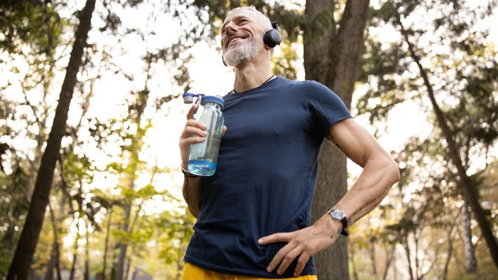 Low,Angle,Of,Smiling,Fit,Bearded,Male,Drinking,Water,After