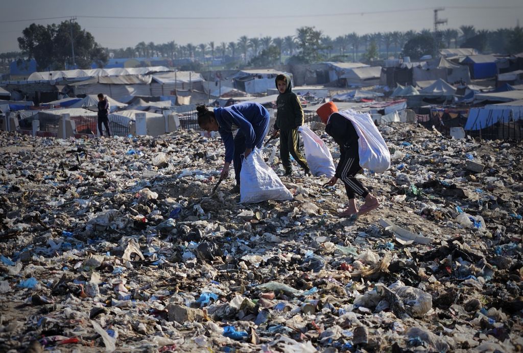 Palestinian kids collect wood and plastic waste amid the ongoing Israeli attacks