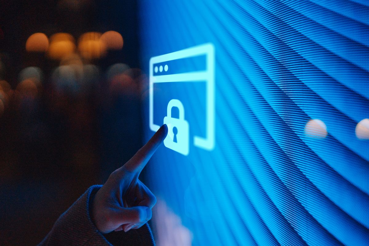 Close-up of  female hand touching illuminated digital screen displaying a locked sign