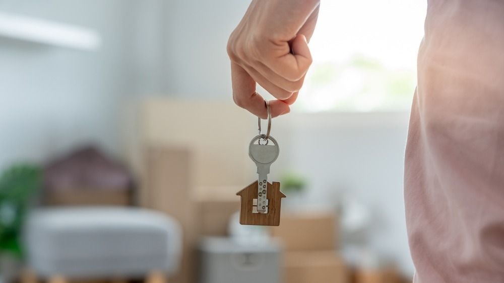 Moving,House,,Relocation.,Woman,Hold,Key,House,Keychain,In,New