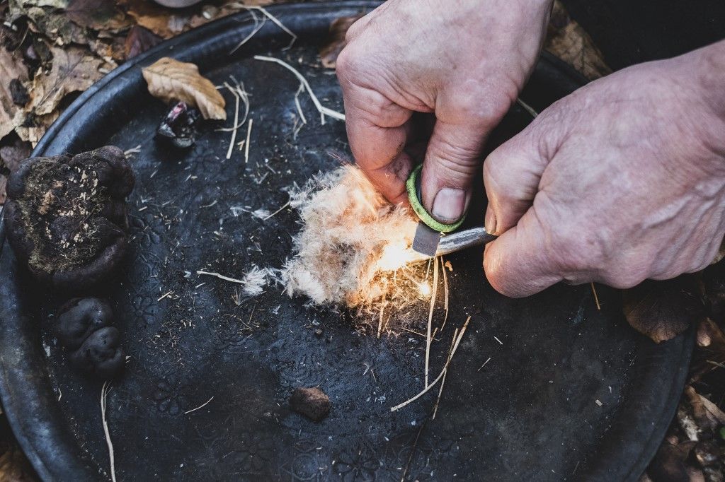 High angle close up of person igniting tinder to start a campfire.
bushcraft
túlélés