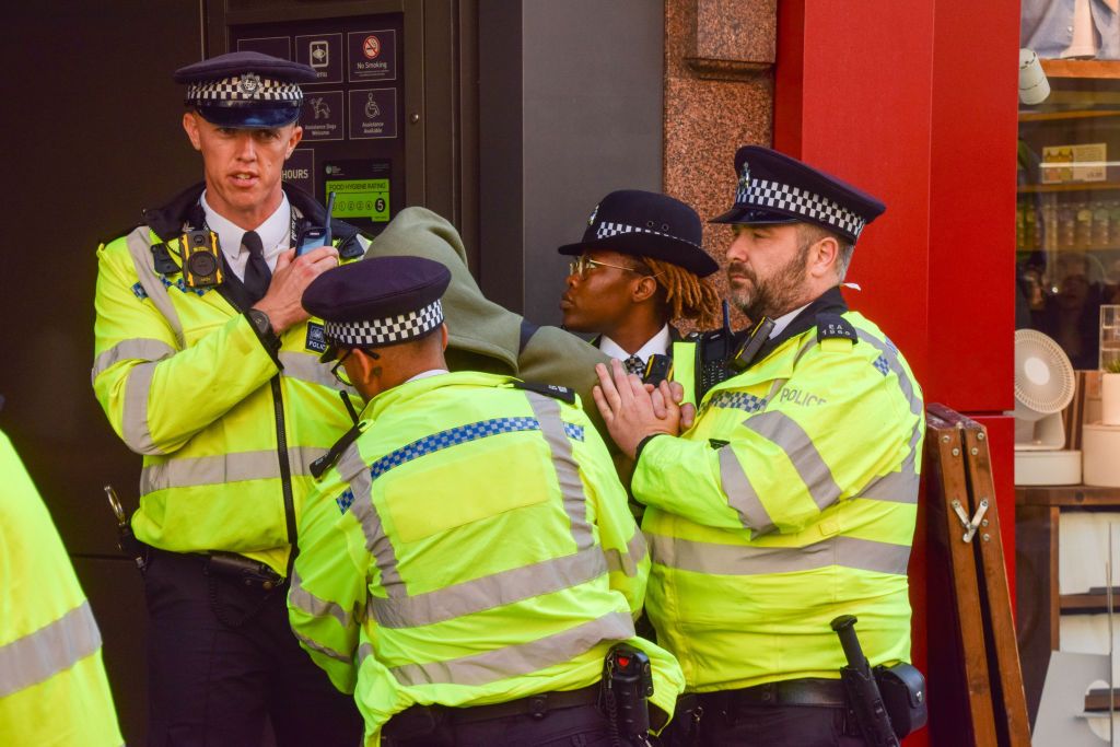 Police officers detain a young man on Oxford Street lopnak