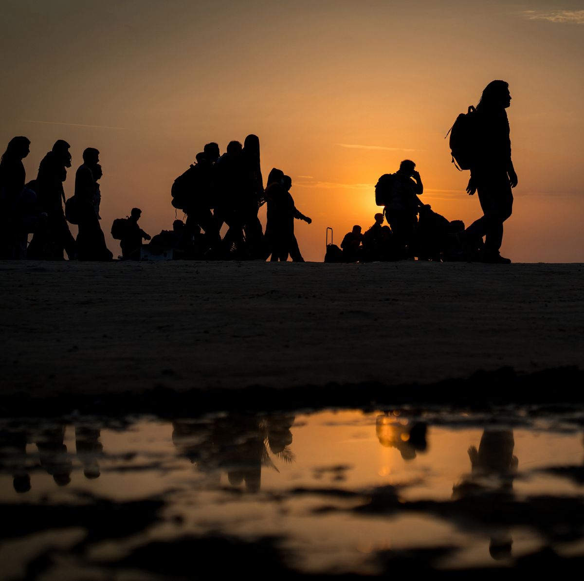 Bevándorlók: romantikus ábrázolás, de észszerű-e az indoklás? Column of migrants walking to the border, immigration crisis