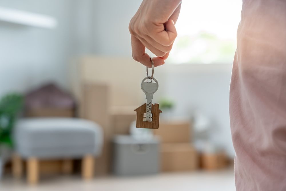 Moving,House,,Relocation.,Woman,Hold,Key,House,Keychain,In,New
