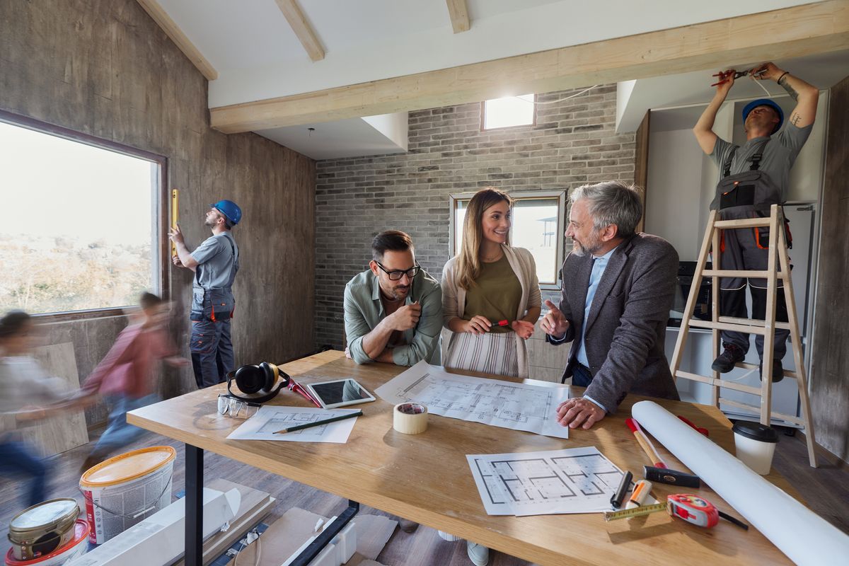 Happy parents making plans with an architect during home renovation process.