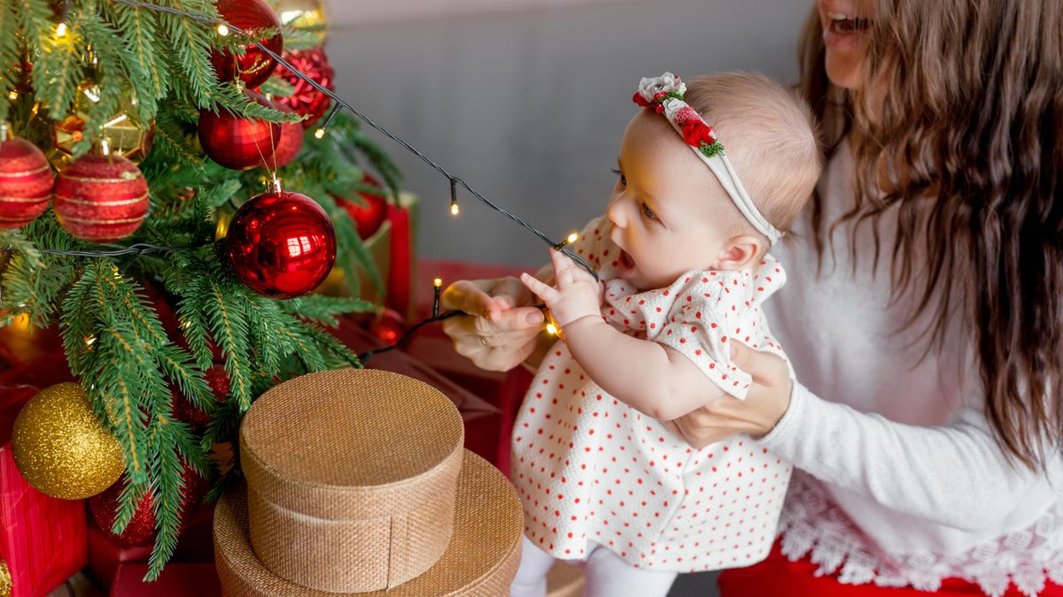 A,Baby,Pulls,A,Garland,With,Lights,From,A,Christmas