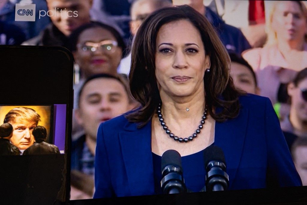 Egy képernyőkép Kamala Harrisról szomorú arckifejezéssel, mögötte támogatóival a CNN Politics csatornán