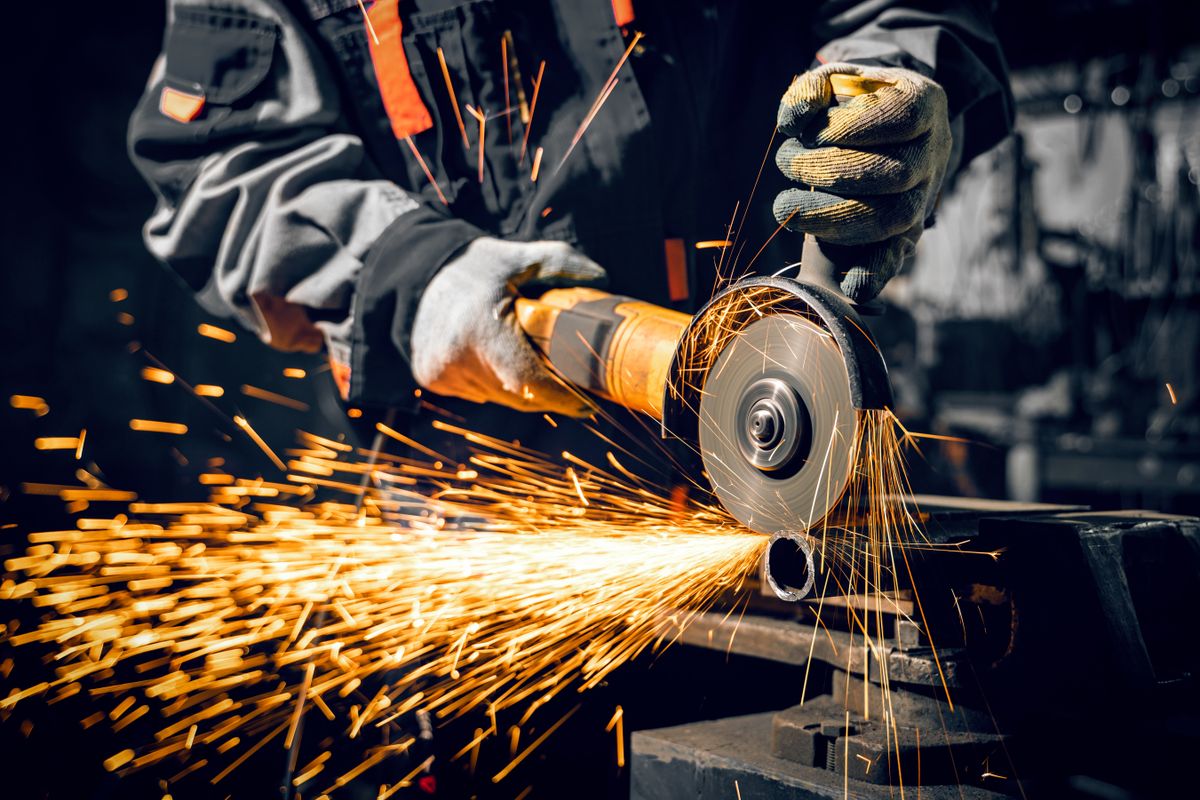 Angle,Grinder,At,Work,,Sparks,And,Dust,From,The,Cut-off vám vámháború acél- és alumíniumimport Trump