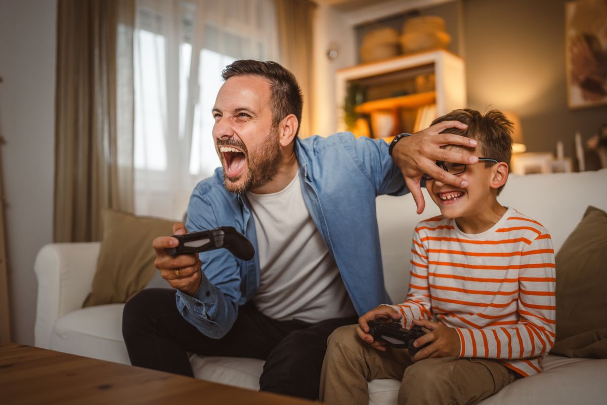 Adult,Caucasian,Father,And,Son,Play,Video,Games,With,Joystick videójáték-ipar top 10 felvásárlás üzlet