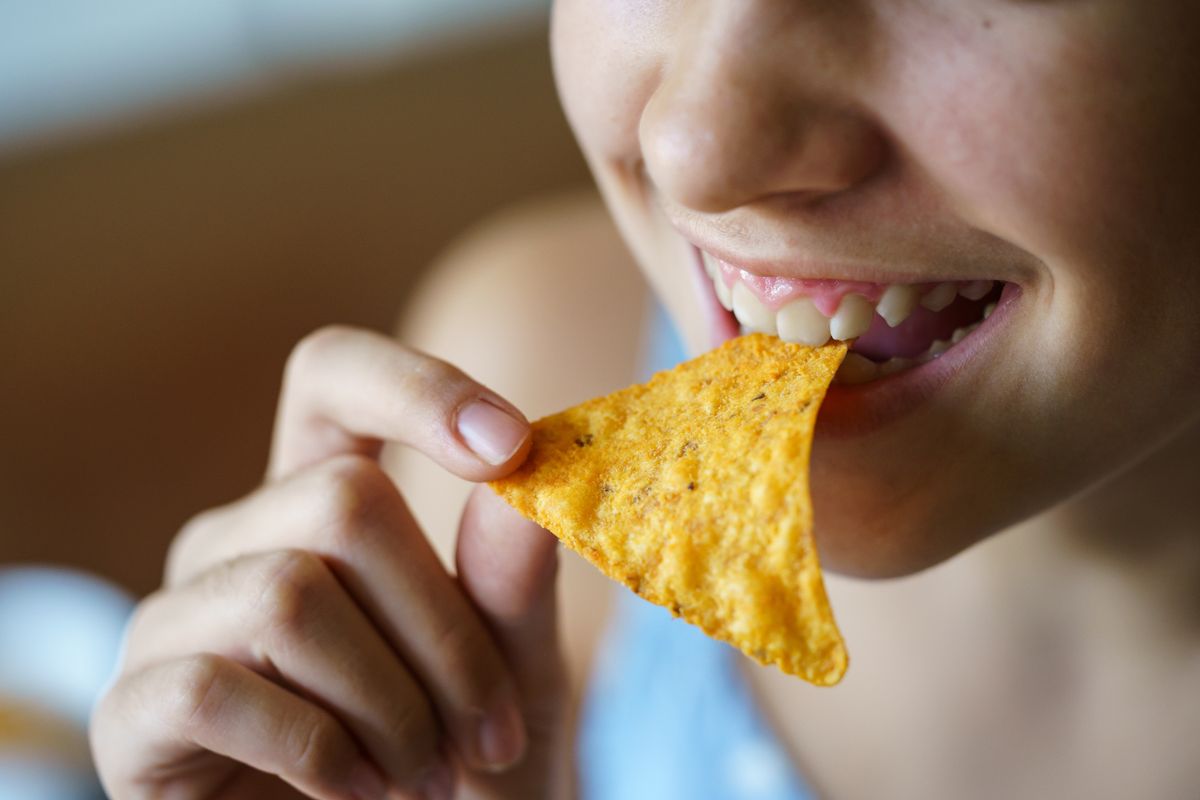 Closeup,Of,Crop,Anonymous,Young,Girl,Smiling,While,Eating,Spicy