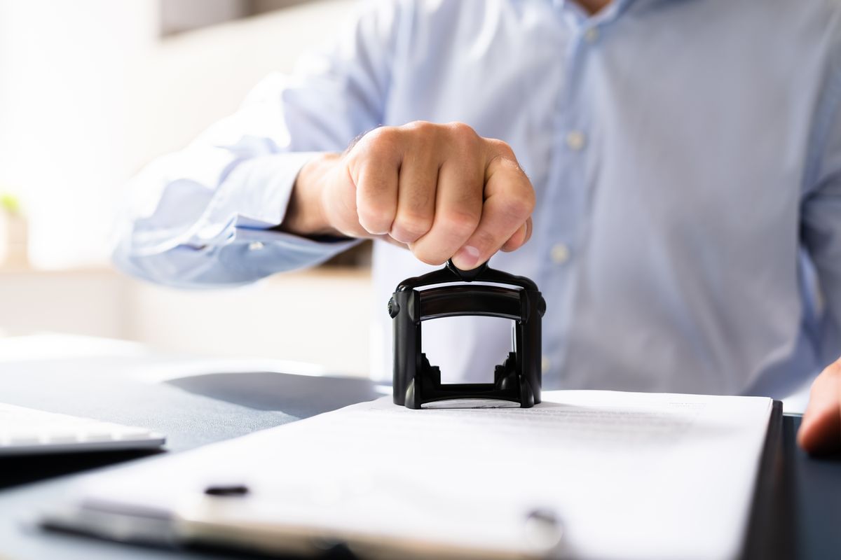 Close-up,Of,A,Person's,Hand,Stamping,With,Approved,Stamp,On DatAdat 