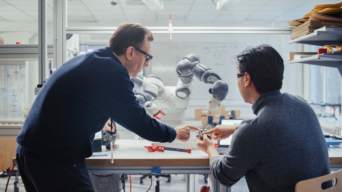 Engineers examining robotic arms in research laboratory meta arm