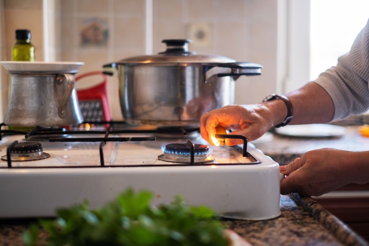 Hand,Adjusting,Gas,Burning,From,A,Kitchen,Gas,Stove
gáz