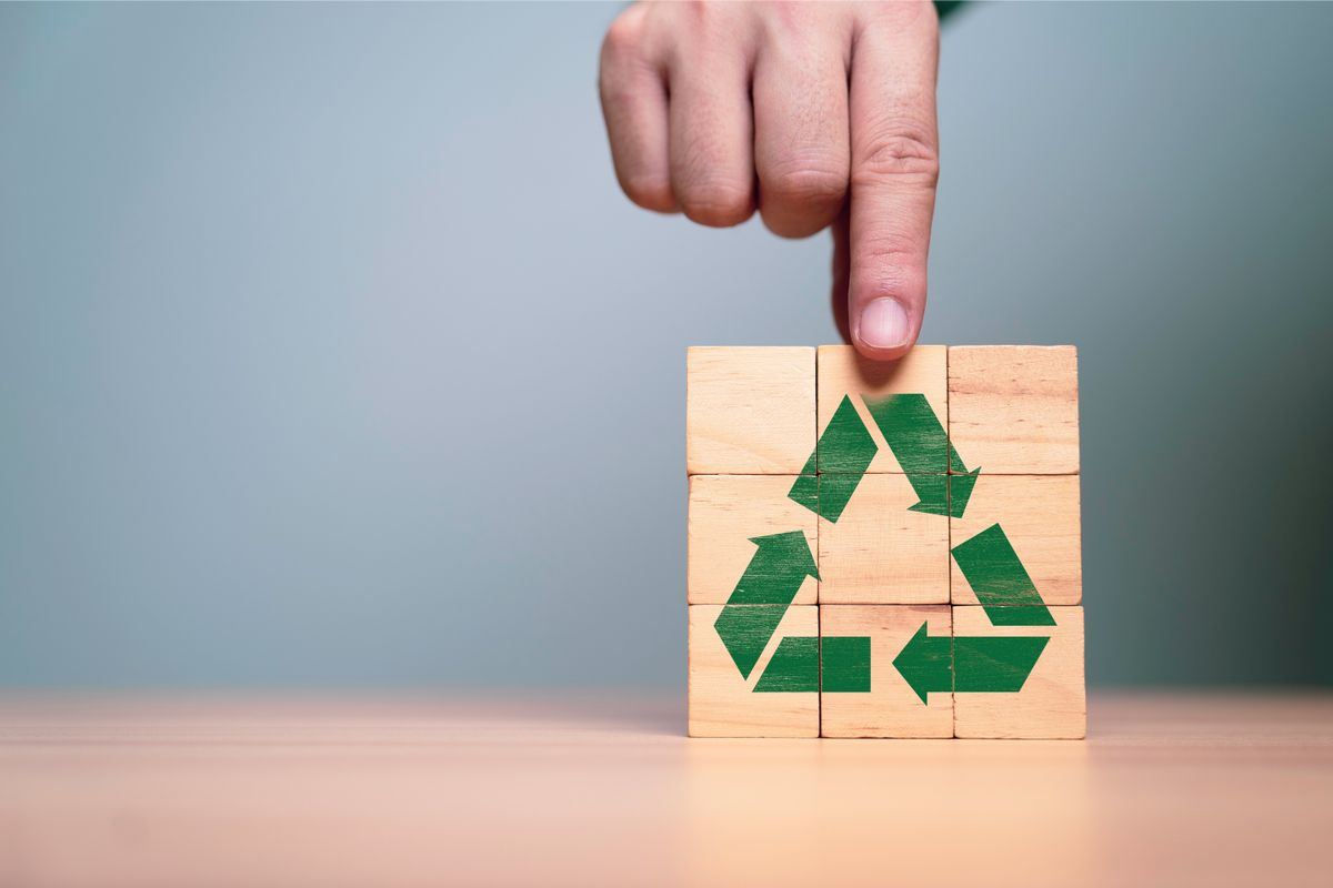 Hand,Holding,Green,Recycle,Label,On,Wooden,Block,Cube,For