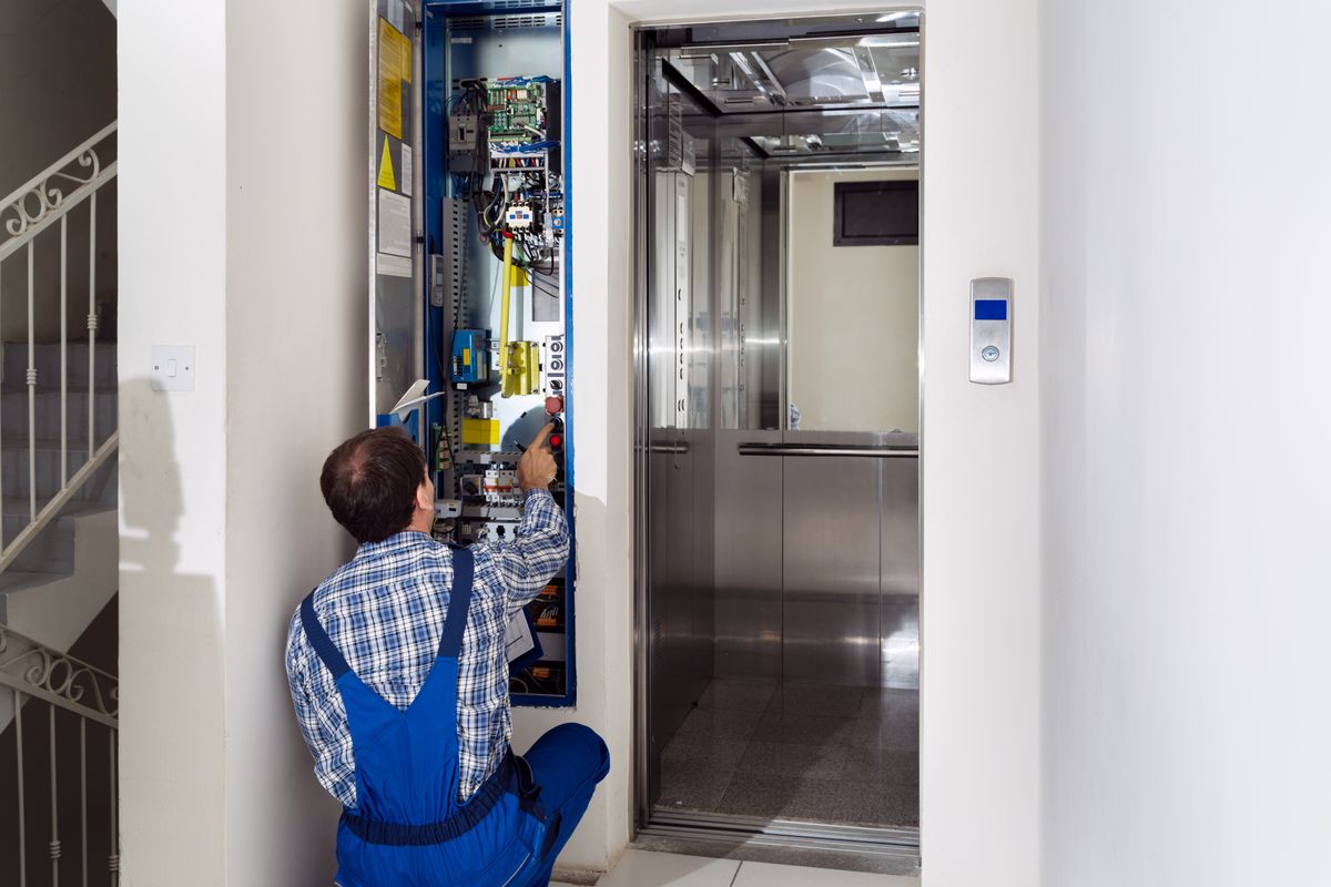 Technician,Repairing,Control,Panel,Of,Broken,Elevator