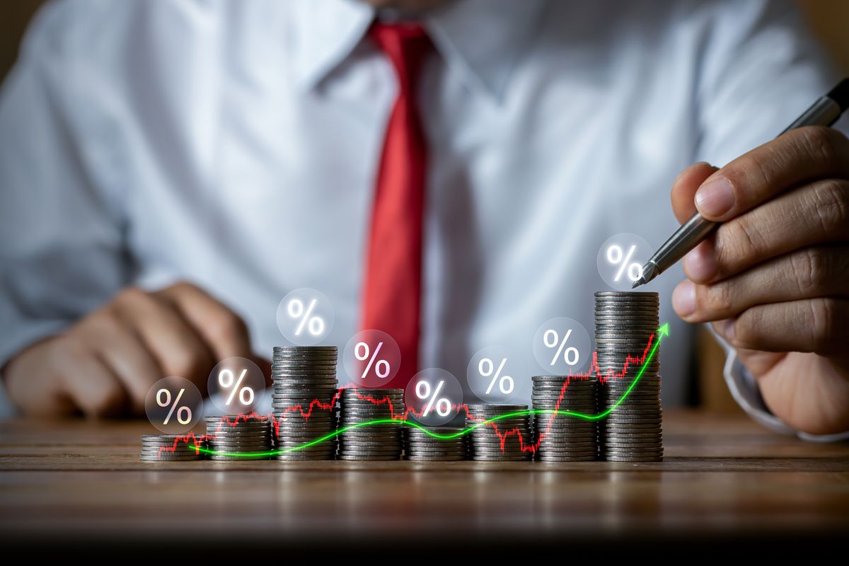 befektetés, ETF, befektetők, Businessman,Putting,Down,Money,,Pointing,With,Pen,And,Showing,Candlestick