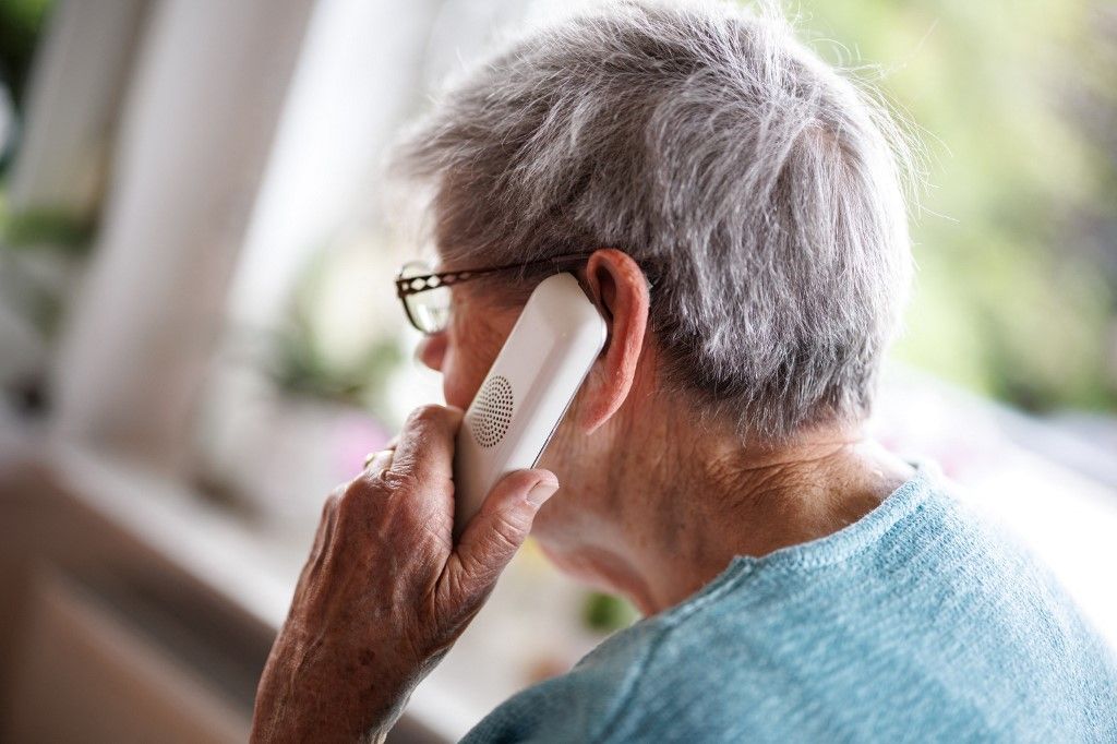 Senior citizen on the phone in her apartment Telefonos csalók élnek vissza a népegészségügyi központ nevével