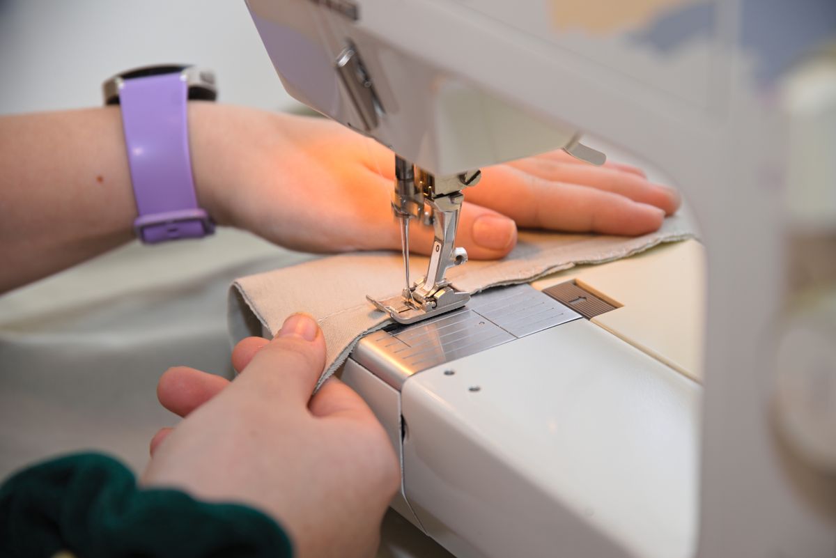 Person,Working,With,Sewing,Machine,To,Hem,Textiles,-,Close-up, románia