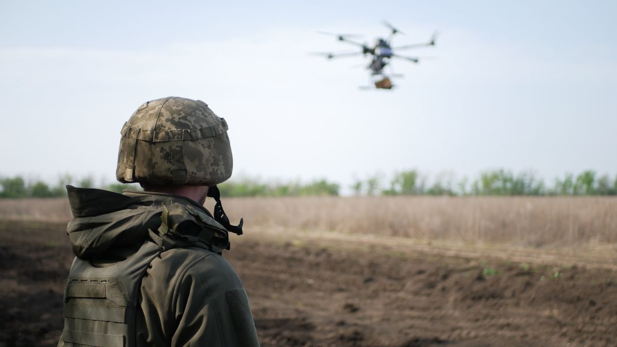 A,Soldier,In,Camouflage,Observes,A,Drone,Hovering,Above,An, katonai innováció, katona