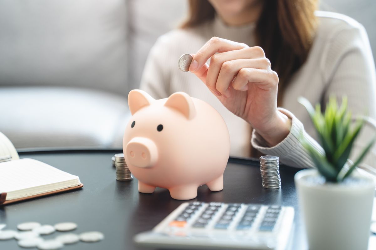 Young,Woman,Saving,Money,Monthly,Expenses,Putting,Coin,In, megtakarítás, malacpersely, pénz, takarék