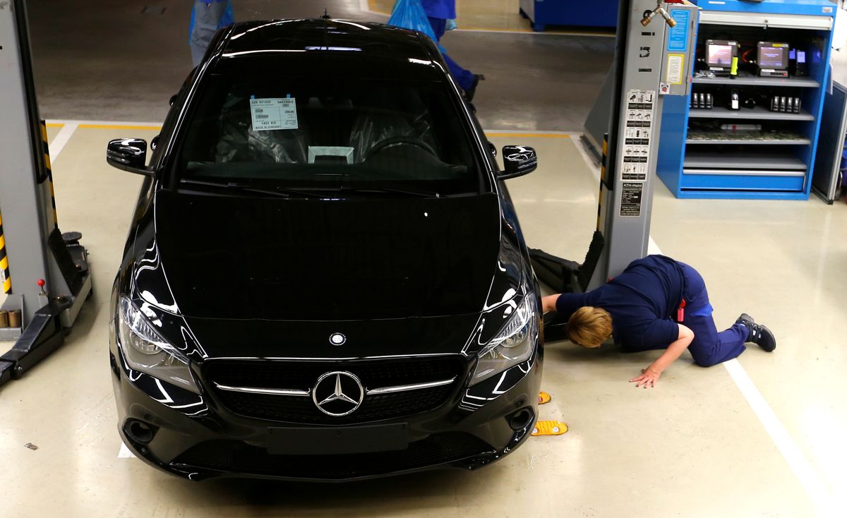 Factory worker inspects cars on the assembly line at Daimler's Mercedes factory in Kecskemet, Hungary