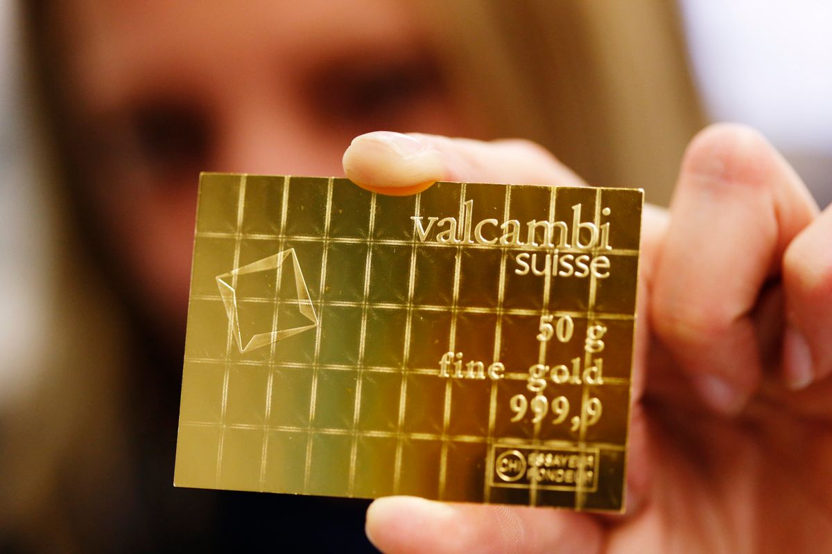 An employee shows a gold Combibar at a plant of gold refiner and bar manufacturer Valcambi SA in the southern Swiss town of Balerna