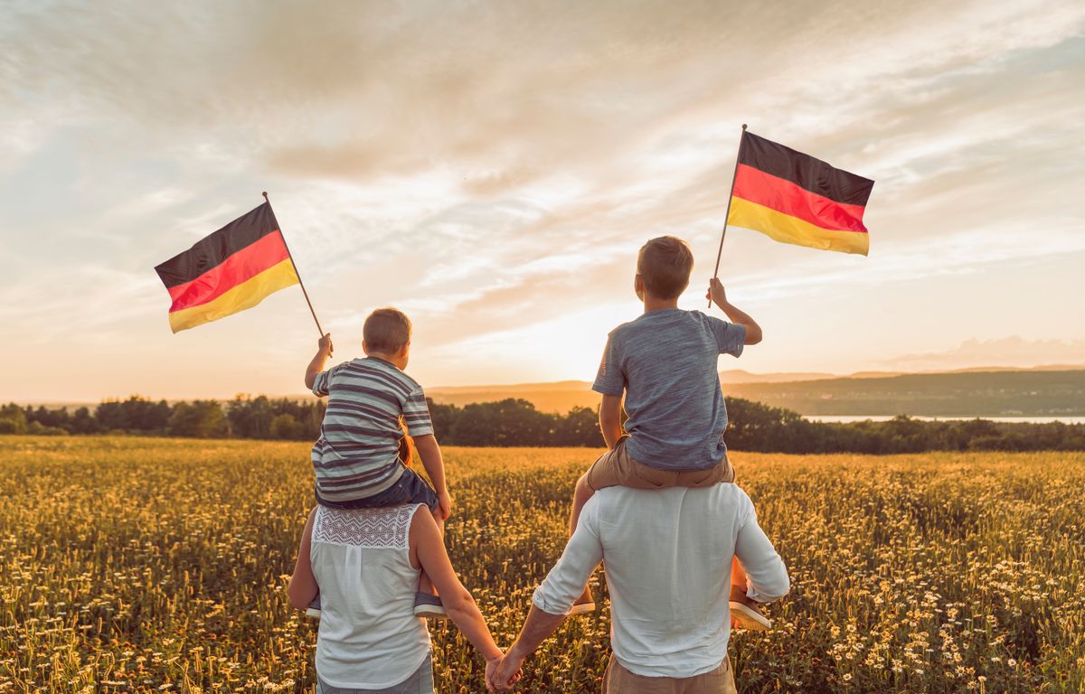A,Patriotic,Family,Waving,Germany,Flag,On,Sunset