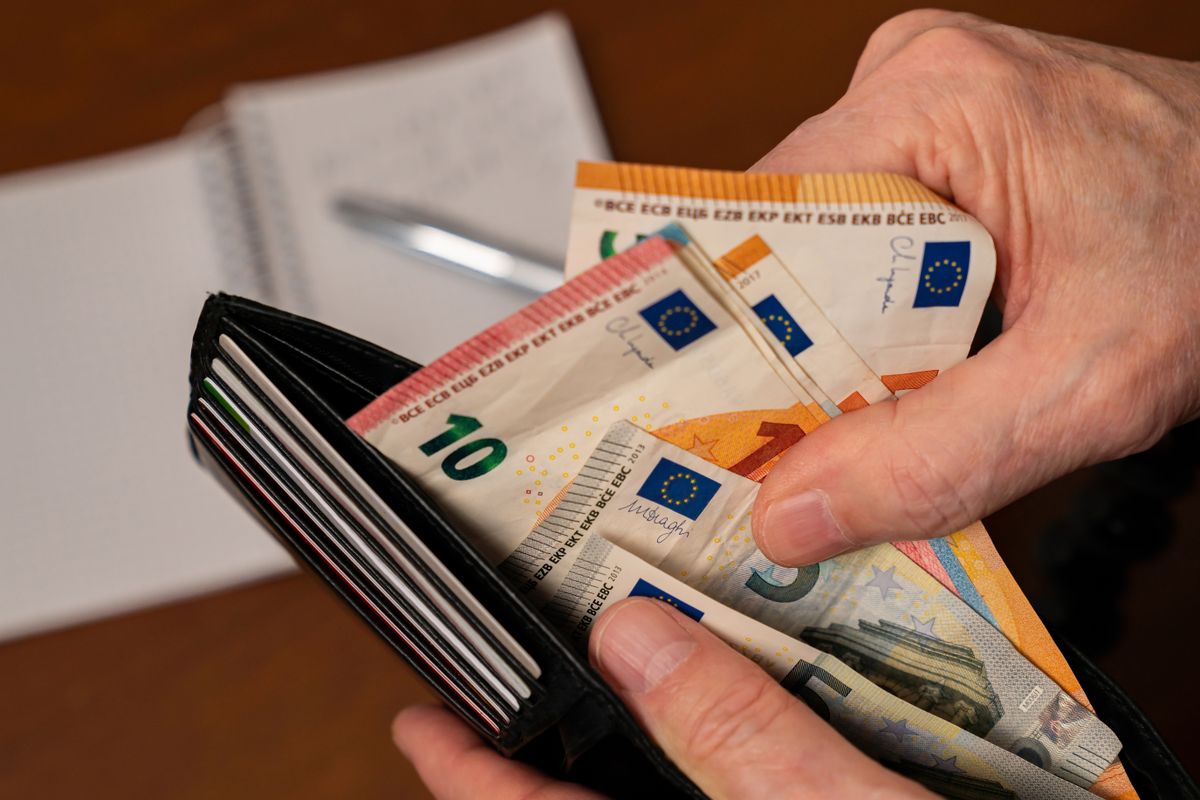 Close-up,Of,A,Man's,Hands,Counting,Money,In,A,Purse.