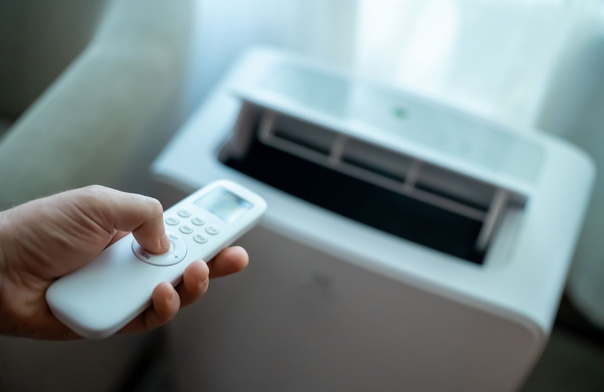 Hand,Holding,Remote,Control,Aimed,At,Floor,Standing,Mobile,Air