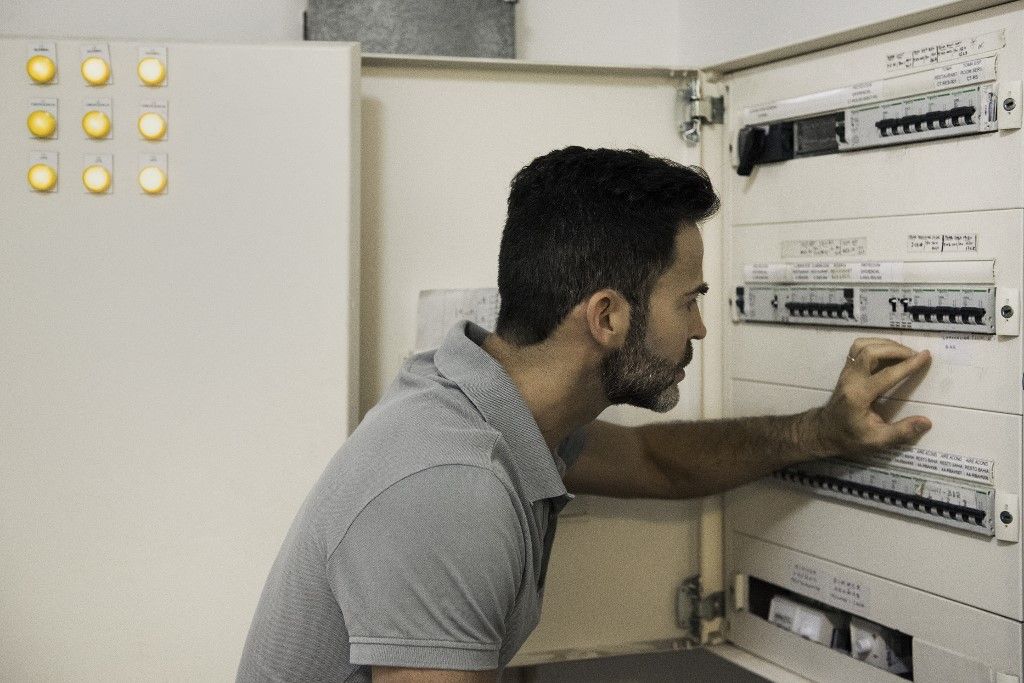 Electrician checking electric control cabinet