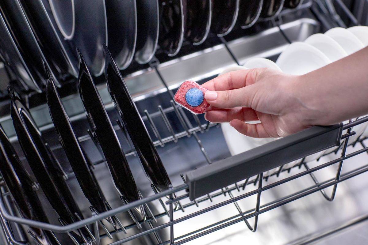 Dishwasher,Tablet,In,A,Woman's,Hands,Against,The,Background,Of