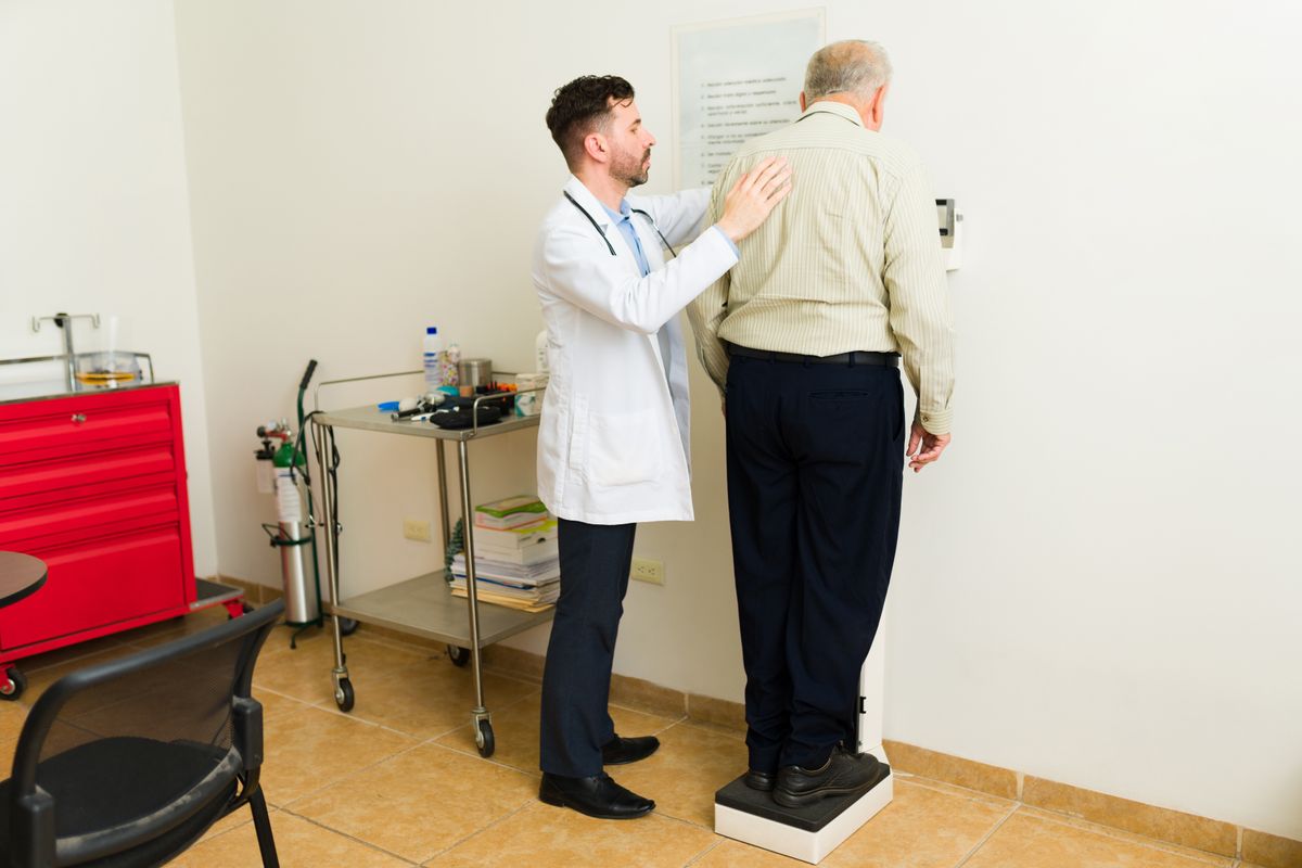 Doctor,Geriatrician,And,Sick,Mature,Elder,Patient,Seen,From,Behind