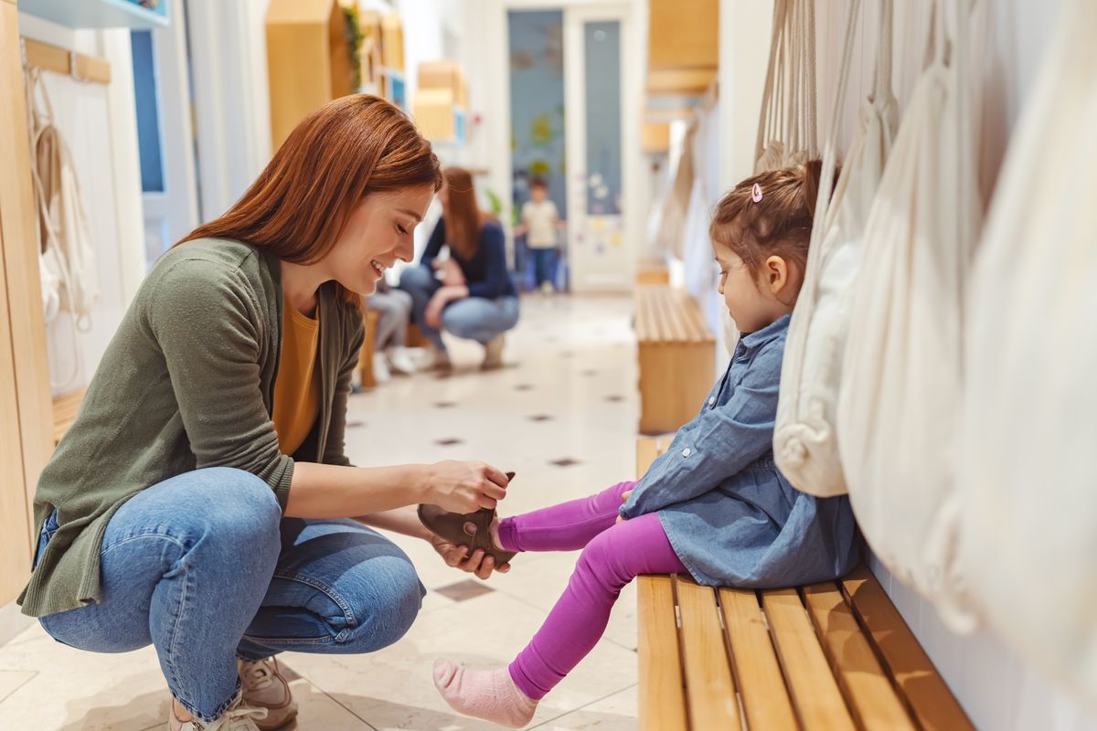 The,Mother,Helps,Her,Cheerful,Child,Put,On,Shoes,In