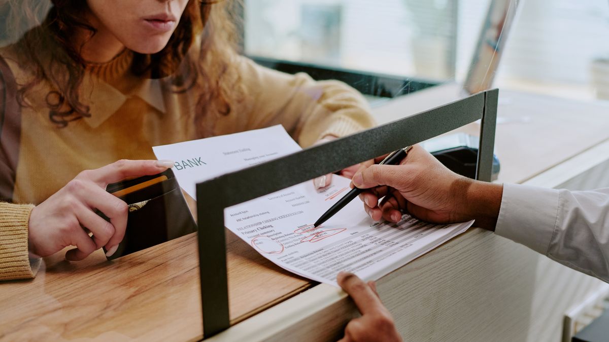 jelentés,Detailed,View,Of,Person,Filling,Out,Forms,At,Bank,Counter,