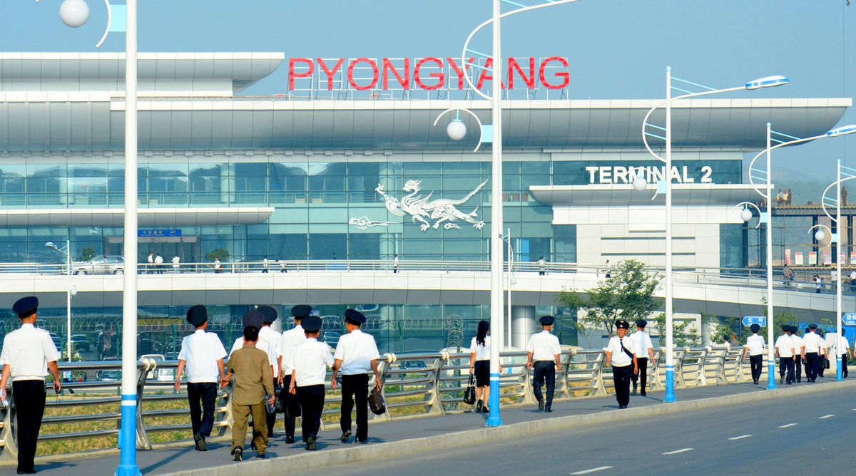 Pyongyang airport officials walk toward new terminal building