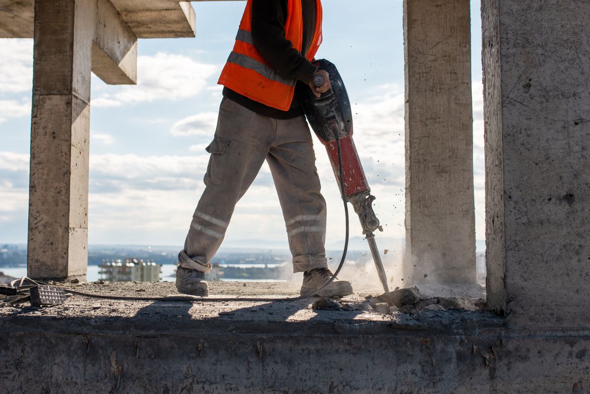 fizetésemelés Construction,Worker,Using,Jackhammer,To,Drill,Concrete,Floor.